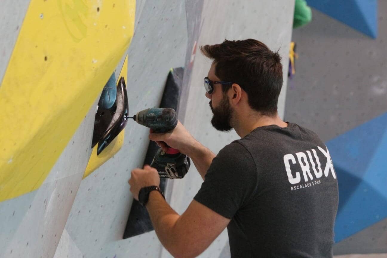 Kévin réalise de l'ouverture de voies d'escalade.