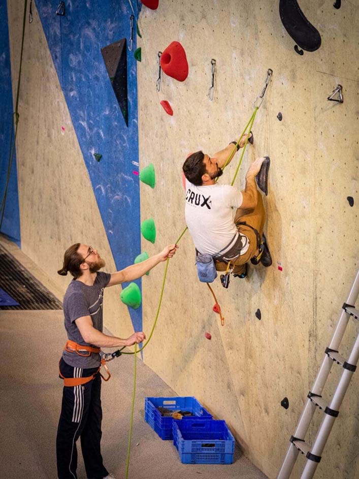 Kévin escalade un mur. 
